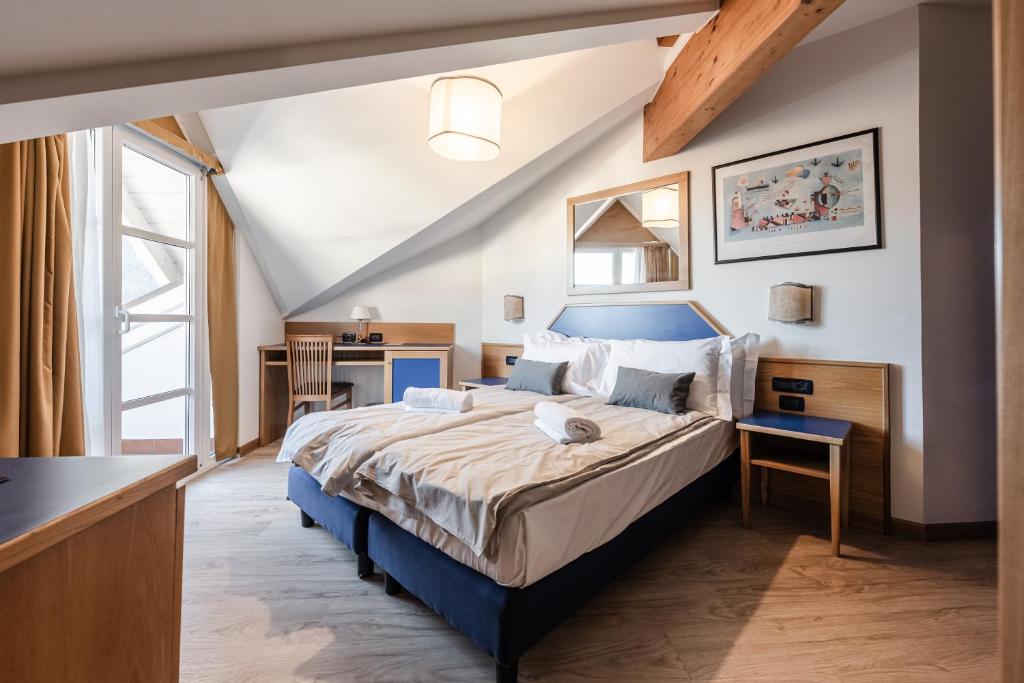 una camera con un grande letto con testiera blu di Hotel garni Meledrio a Dimaro