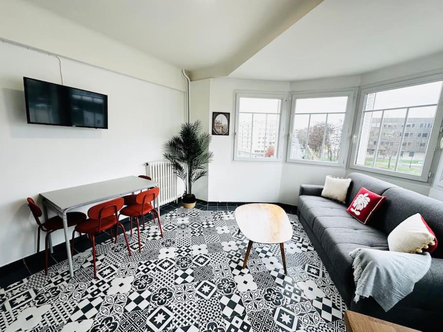 a living room with a couch and a table at Le Gentil Rooftop in Gentilly