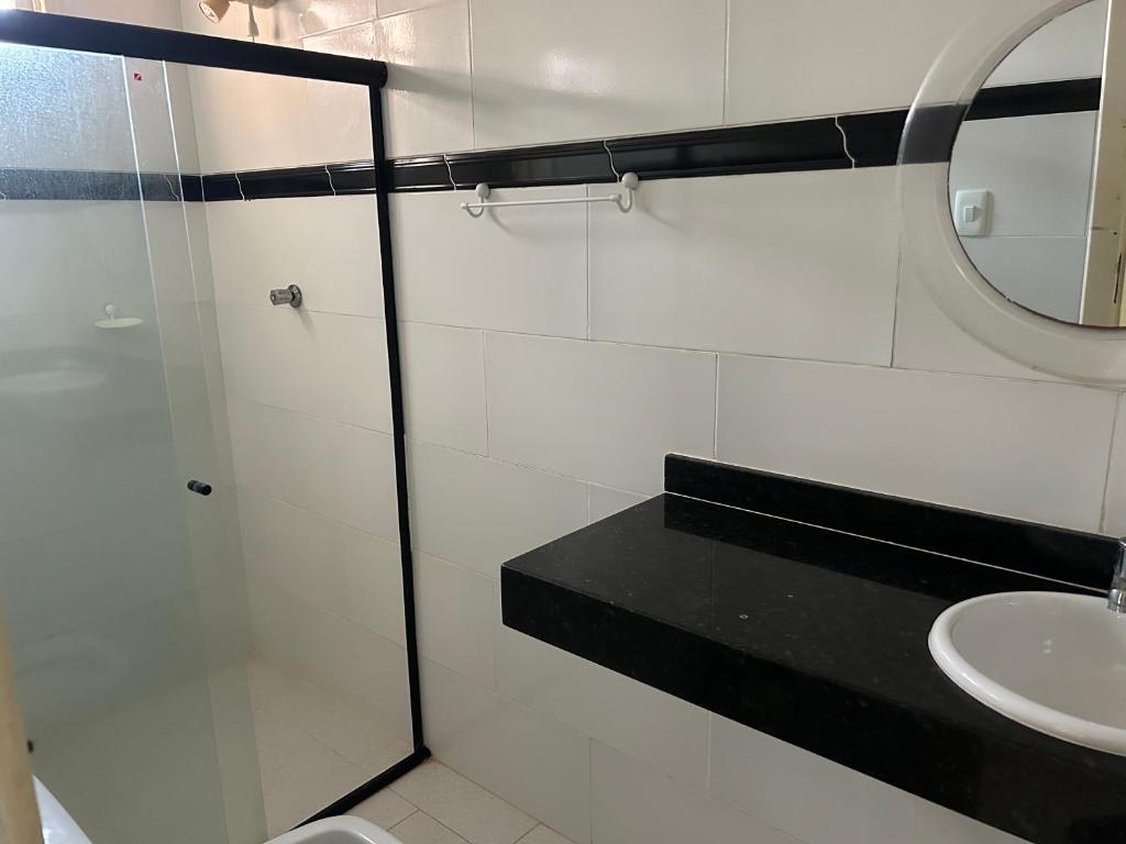 bagno bianco con lavandino e specchio di Chalet Sol Nascente a Lauro de Freitas