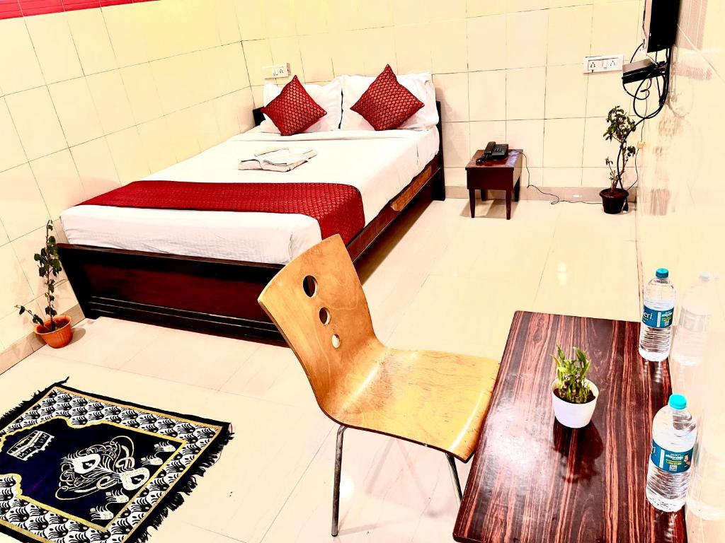 HOTEL SITA GRAND في شامشاباد: غرفة نوم بسرير وكرسي وطاولة
