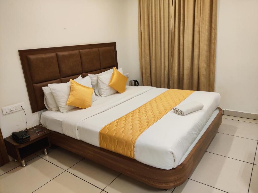 a bedroom with a large bed with yellow pillows at Relax Inn in Bangalore