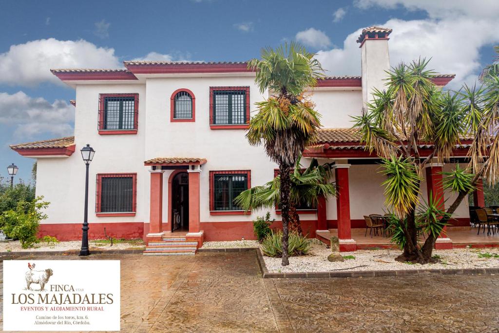 una grande casa bianca con un cartello davanti di Finca Los Majadales ad Almodóvar del Río