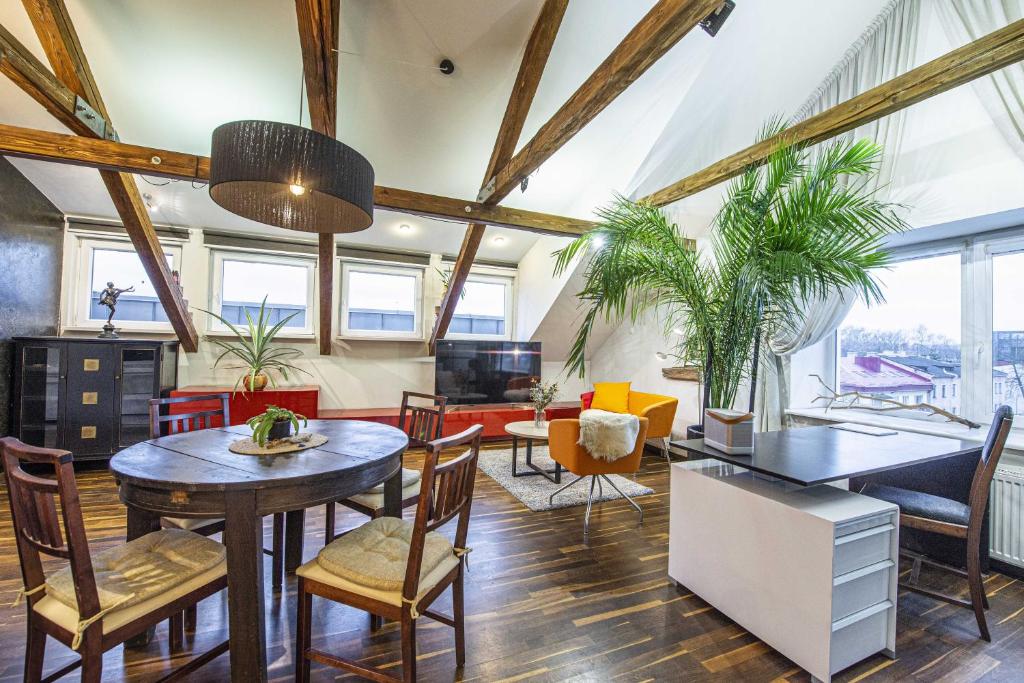 a living room with tables and chairs and windows at Apartment between Akropolis and Soboras in Kaunas