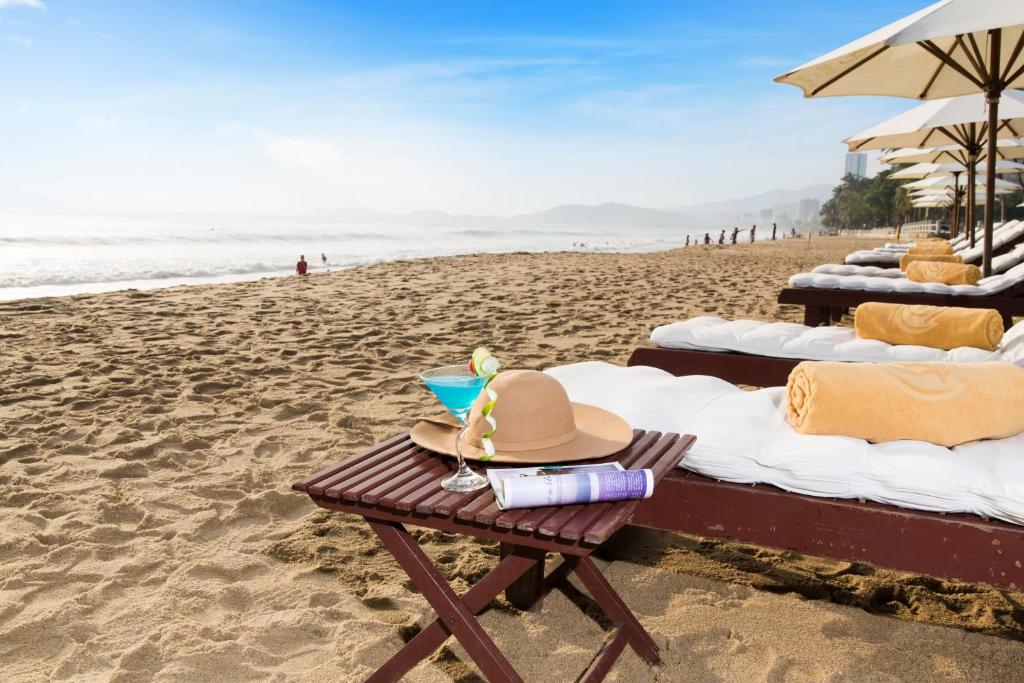 - un chapeau sur une table de pique-nique sur la plage dans l'établissement TTC Hotel - Michelia, à Nha Trang