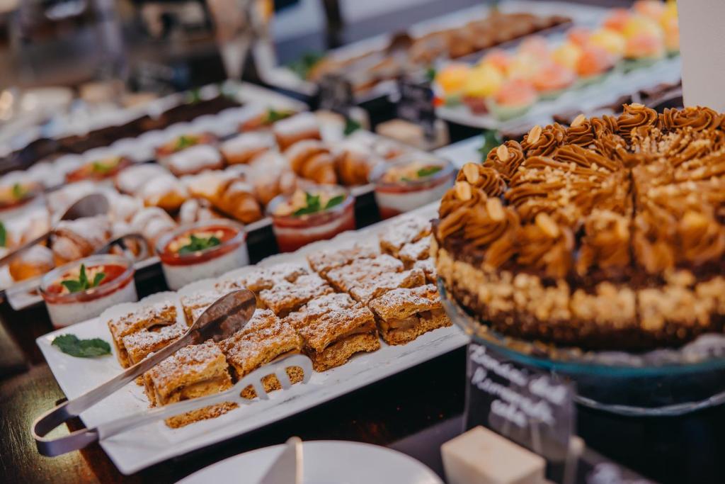 a buffet filled with different types of desserts and pies at Wenceslas Square Hotel - Czech Leading Hotels in Prague
