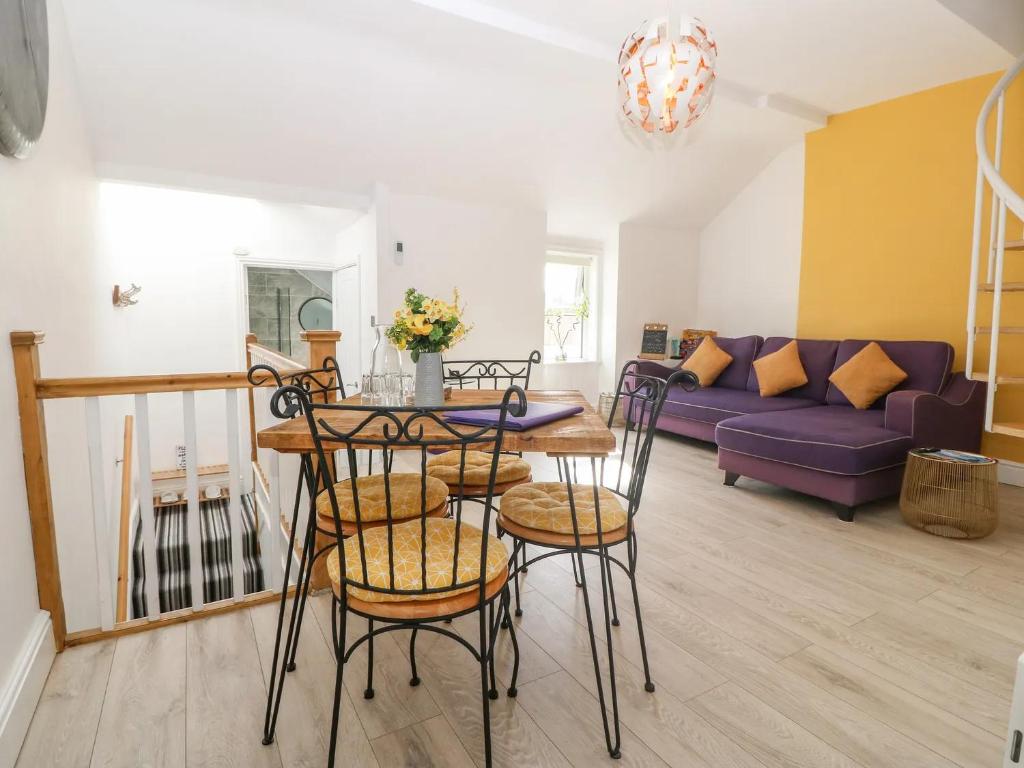 ein Wohnzimmer mit einem Tisch, Stühlen und einem Sofa in der Unterkunft 'Llandudno Central' - 2 Bed Luxury Flat, Close to Town and Beaches in Llandudno