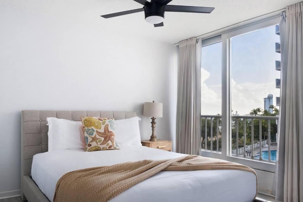 een slaapkamer met een bed en een raam met een balkon bij Media Luna Studio Oceanview Pool in San Juan