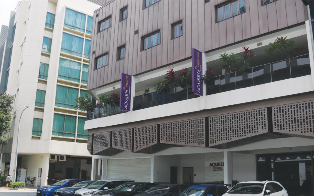 een gebouw waar auto's voor geparkeerd staan bij Aqueen Prestige Hotel Lavender in Singapore