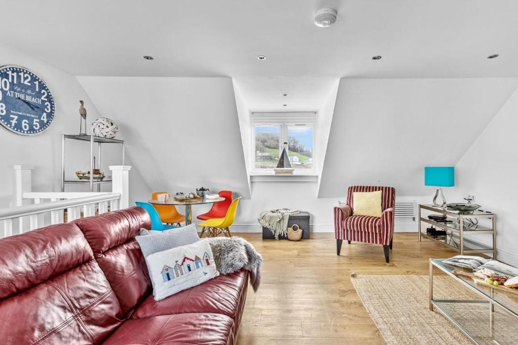 a living room with a brown leather couch and chairs at 17 At The Beach, Torcross in Torcross