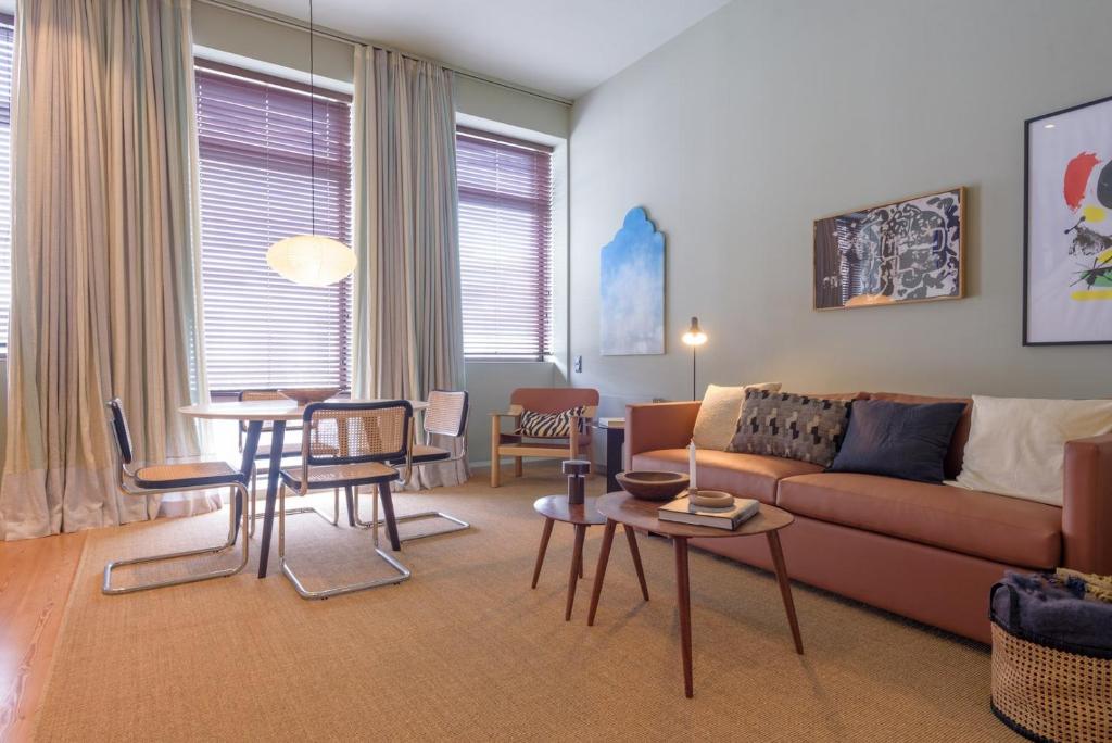 sala de estar con sofá, mesa y sillas en Gilreu Beach Duplex Apartments in Foz by LuxiStay en Oporto
