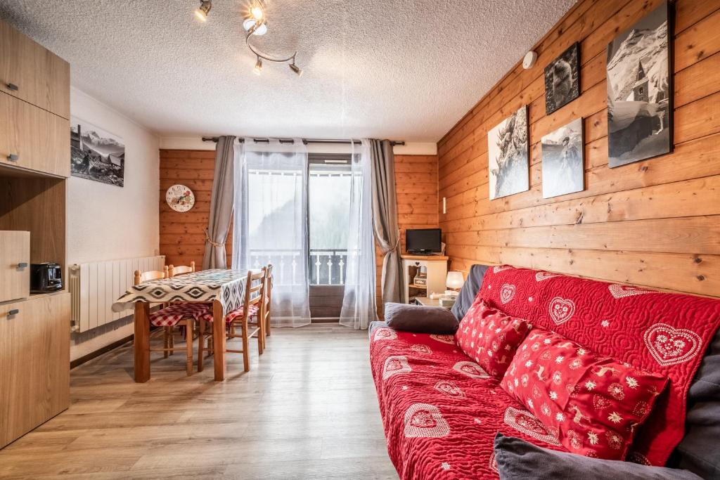 een woonkamer met een rode bank en een tafel bij Coin Tranquille À Châtel Pour 4 in Châtel