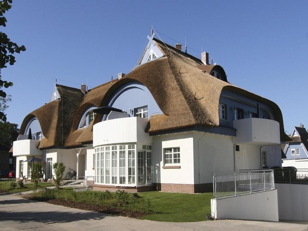 a large white house with a thatched roof at Wellnessresidenz "Klaus Störtebeker" App6 in Zingst