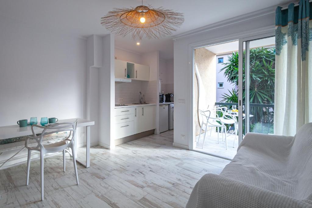 eine Küche und ein Wohnzimmer mit Tisch und Stühlen in der Unterkunft Apartment BEACH & RELAX in Port de Pollença
