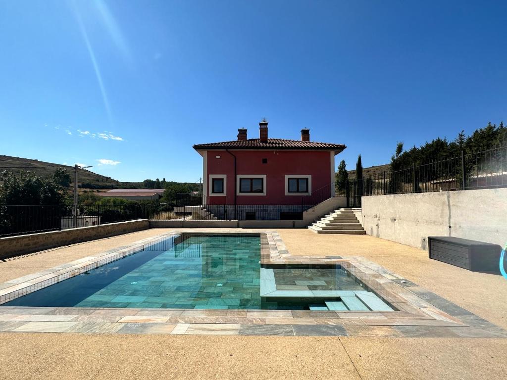a house with a swimming pool in front of a house at La Casa Rosa in Burgos