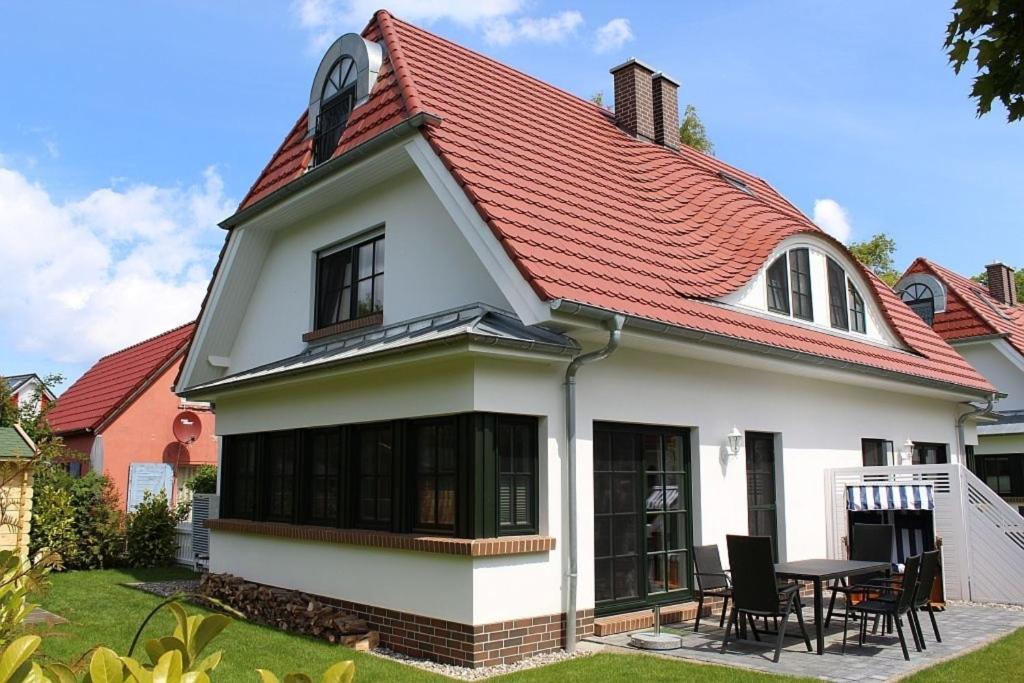 une maison blanche avec un toit rouge dans l'établissement Ferienhaus "Sehnsucht" Störtebekerstr3e, à Zingst