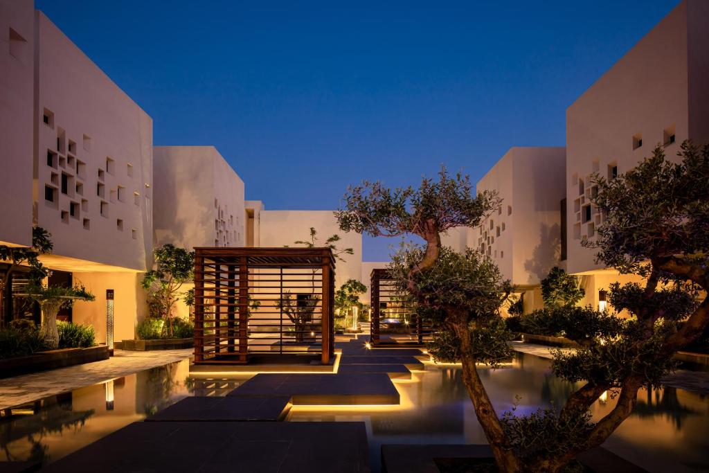 a courtyard of a building with a pool and trees at The Biltmore Hotel Villas in Dubai