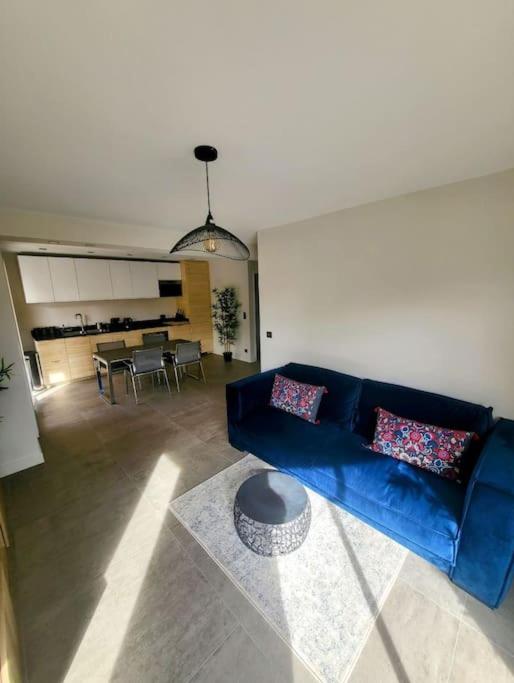 un salon avec un canapé bleu et une table dans l'établissement Appartement MARTINEZ 4 couchages, à Cannes