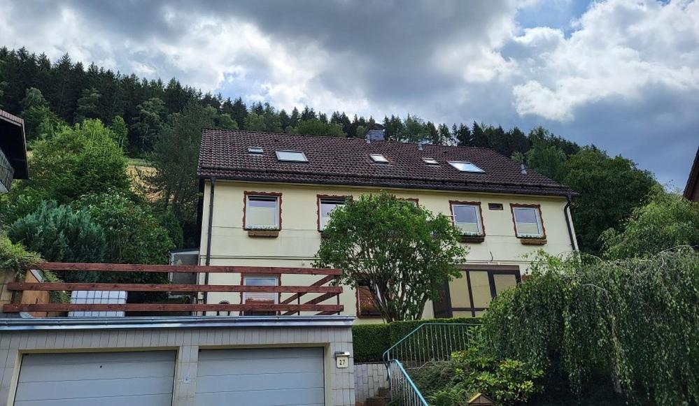 een huis met een garage en een berg bij Birkenstübchen in Lautenthal