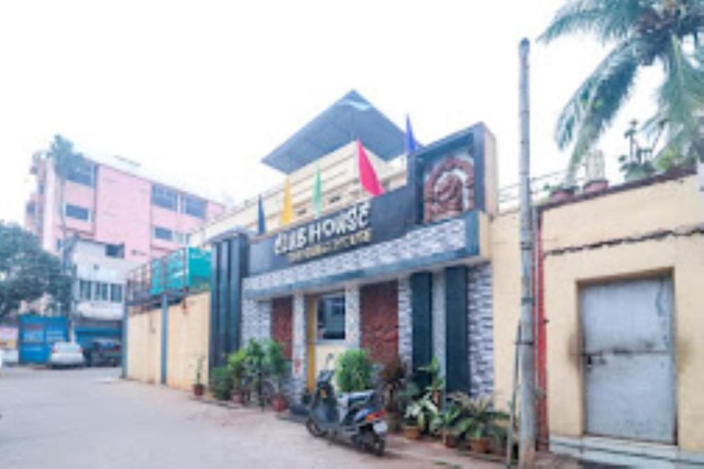 un edificio con una motocicleta estacionada frente a él en Club House Guest House,Bhubaneswar, en Bhubaneshwar