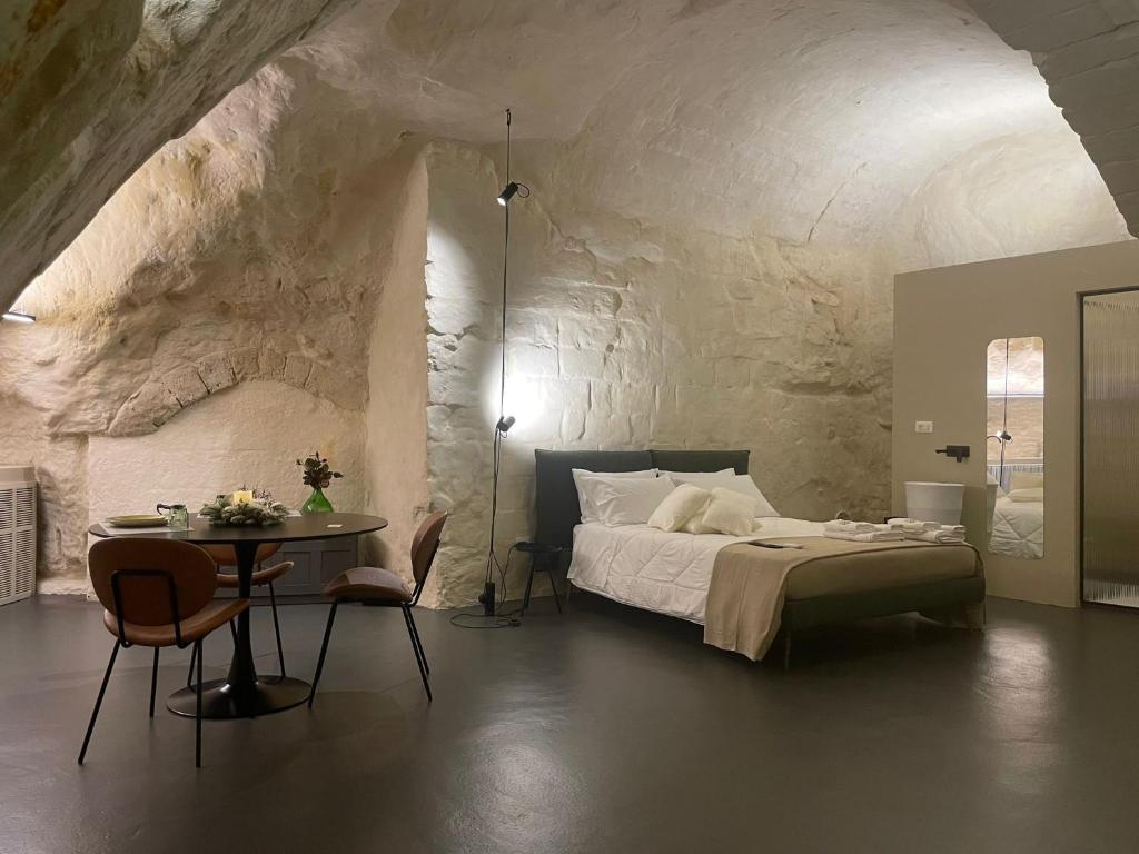 a bedroom with a bed and a table with chairs at Marsili Suite in Matera