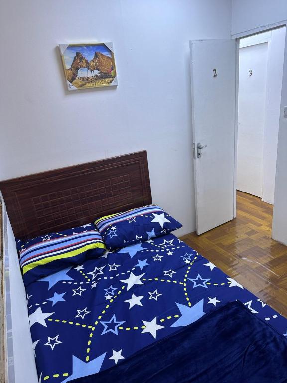 a bed with a blue comforter with stars on it at Decent UNISEX Private Rooms near Burjuman Metro Exit -4 in Dubai