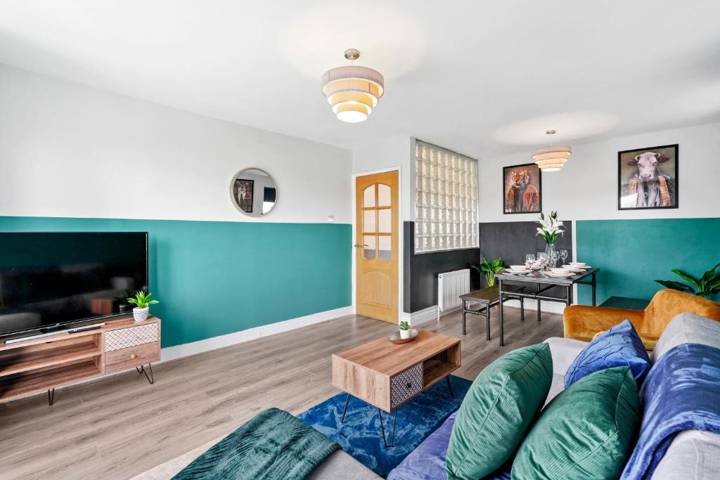 a living room with a couch and a tv at The Stylish Warwick Abode - Balcony - Garden in Leek Wootton