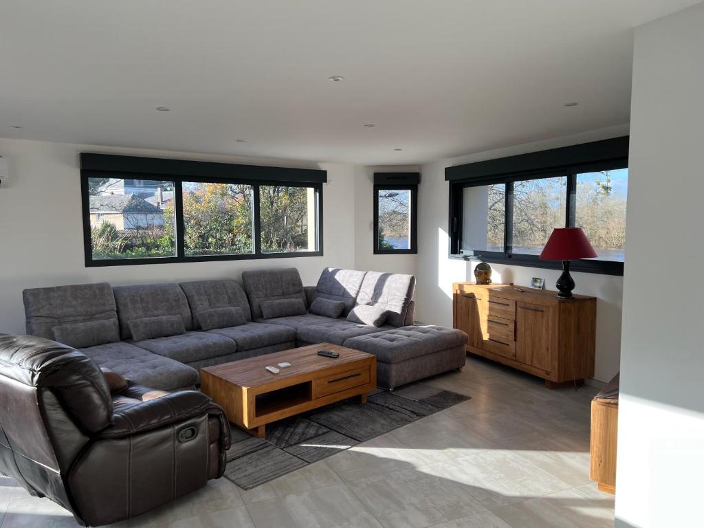 ein Wohnzimmer mit einem Sofa und einem Tisch in der Unterkunft La Corderie in Mûrs-Érigné