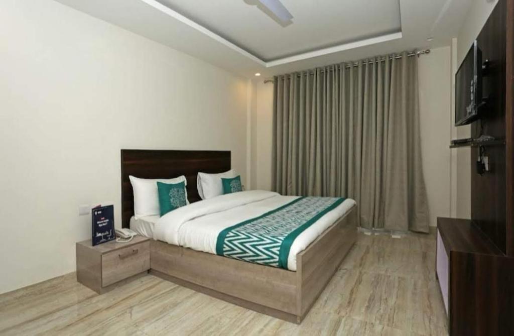 a bedroom with a large bed and a television at Laxmi Stay Hotel in New Delhi