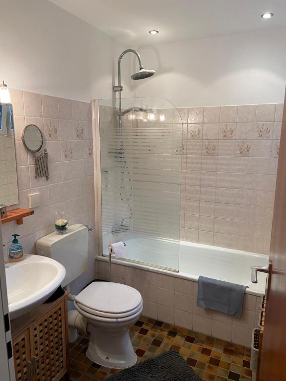 a bathroom with a toilet and a tub and a sink at Ferienhaus Glückspilz beim Hennesee in Meschede