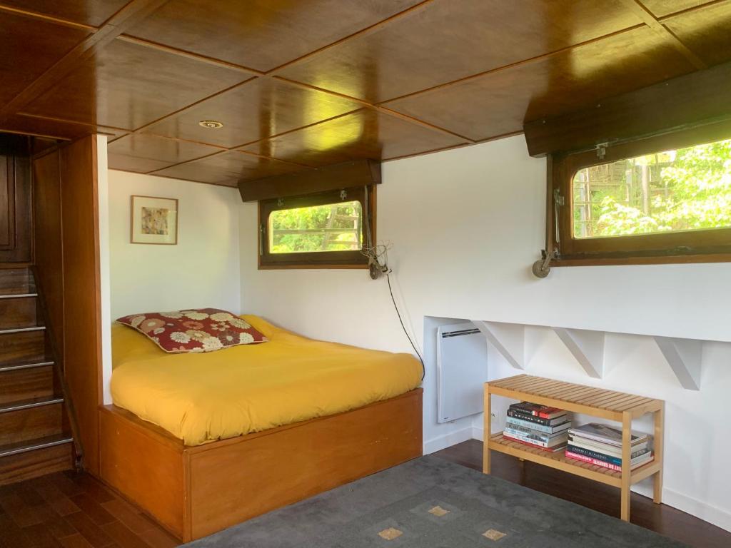 małą sypialnię z łóżkiem w małym domku w obiekcie Péniche Suresnes w mieście Suresnes