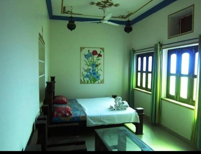 a bedroom with a bed in a room with green lighting at Pushkar Guest House in Pushkar