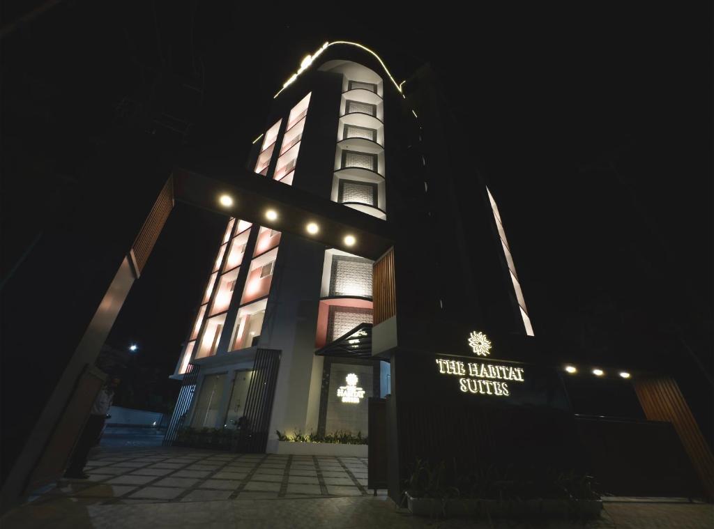 a building with a lit up tower at night at The Habitat Suites in Guruvāyūr