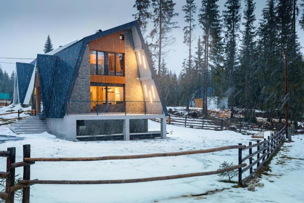 a house with a blue roof in the snow at Winter House TT Jahorina in Jahorina