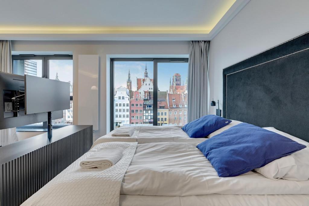 a bedroom with a large bed with a large window at Comfort Apartments Deo Plaza in Gdańsk