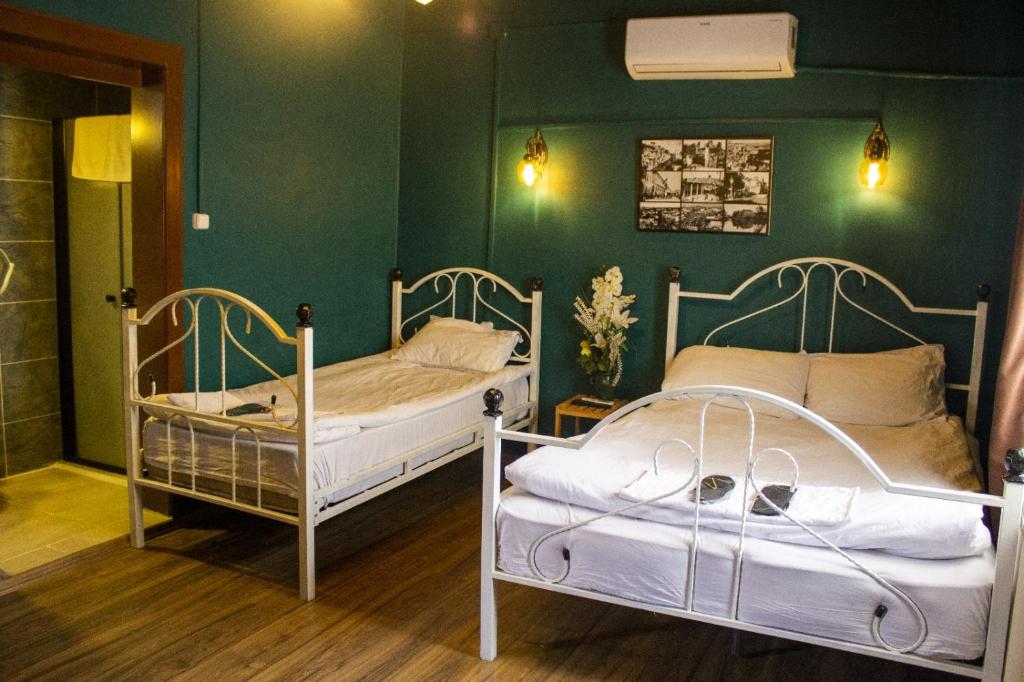 2 łóżka w pokoju z zielonymi ścianami w obiekcie Şirvani Konağı w mieście Gaziantep