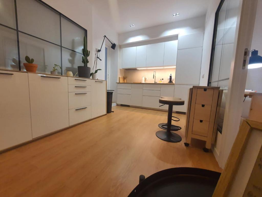 een grote keuken met witte kasten en een tafel bij RentAdore Atocha Suites in Madrid