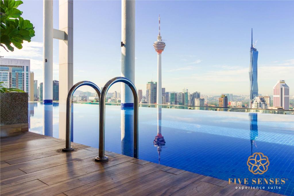 a infinity pool with a view of the city at The Luxe & Colony, KLCC in Kuala Lumpur