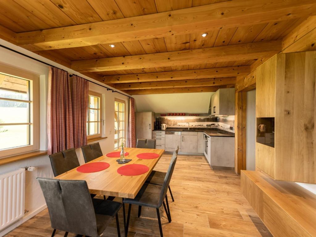 cocina y comedor con mesa de madera y sillas en Holzhof en Breitnau