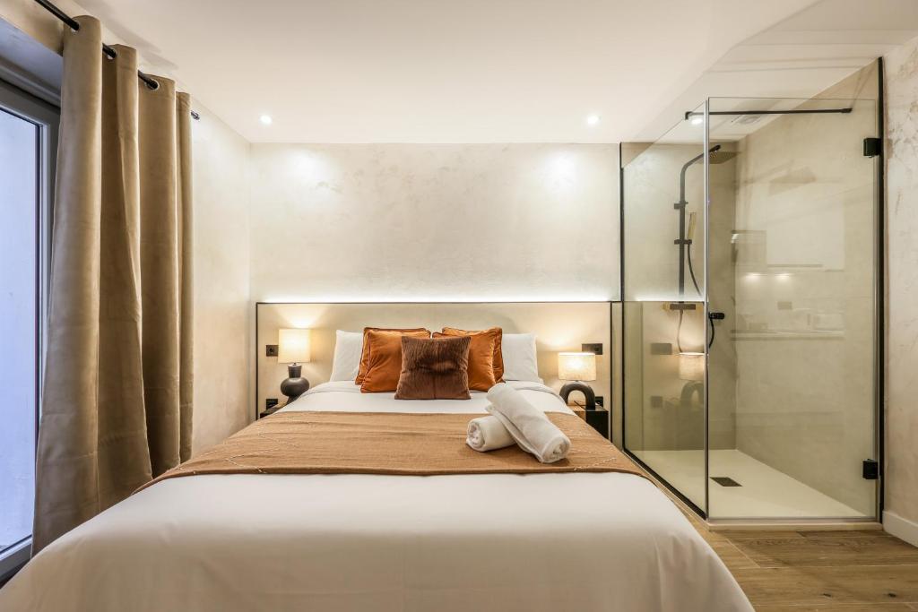 a bedroom with a large bed and a shower at Asequible apartamento a pasos de Callao in Madrid