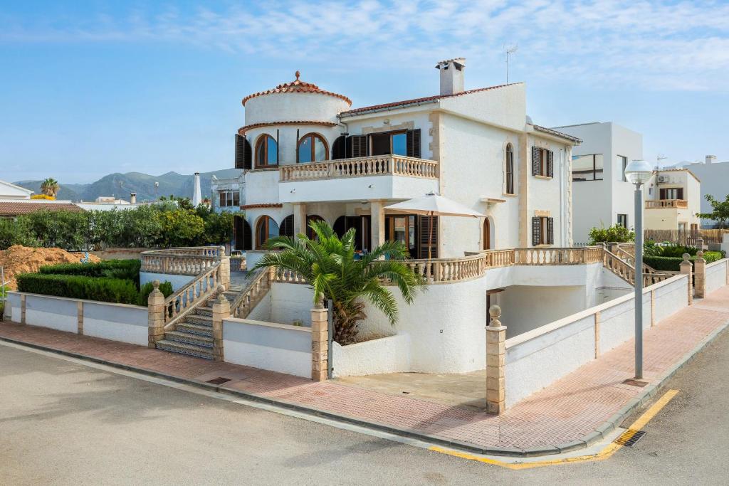 a large white house with a staircase in front of it at Ca n' Auba in Colonia de Sant Pere