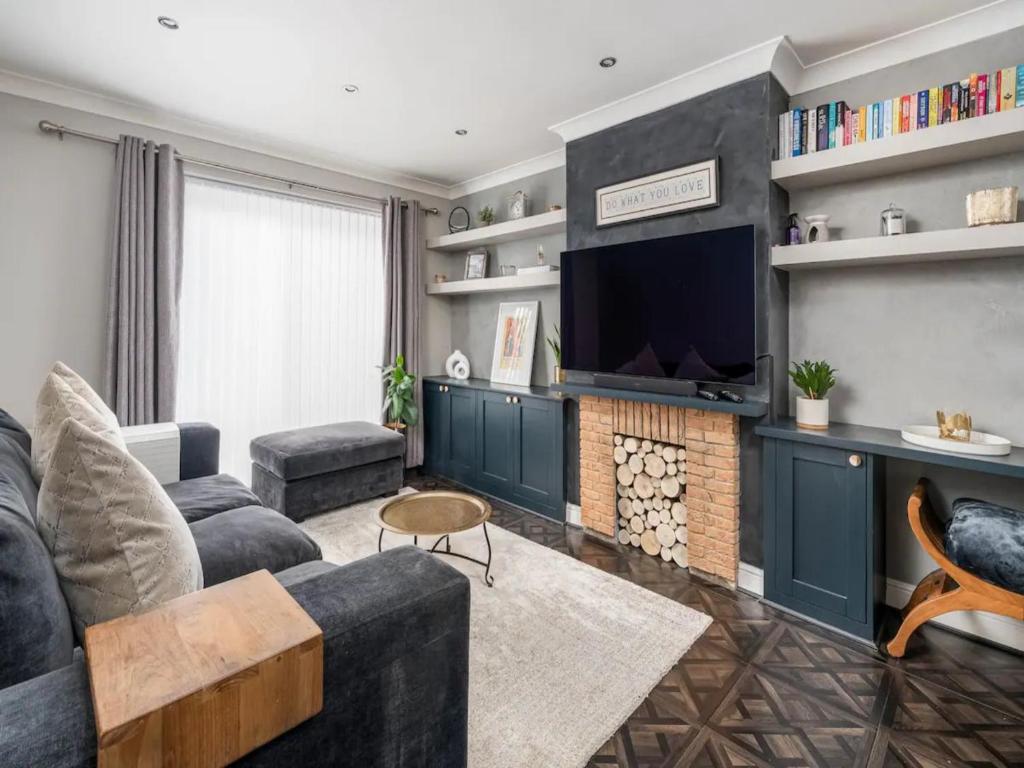 un soggiorno con divano e TV di Pass the Keys Stylish Modern 3 bed house with Parking a Rickmansworth