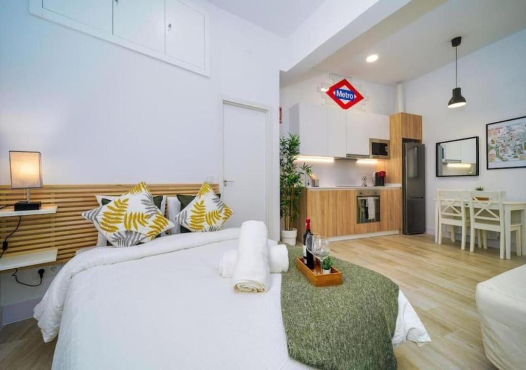 um quarto com uma grande cama branca e uma cozinha em (J4) Loft Céntrico Madrid Retiro A estrenar em Madrid