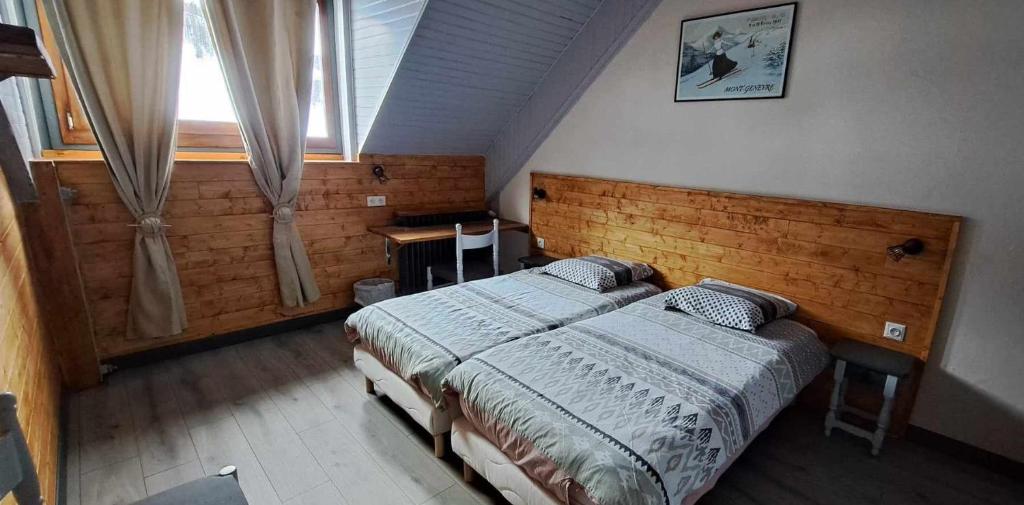 a bedroom with two twin beds and a window at Hotel Valérie in Montgenèvre