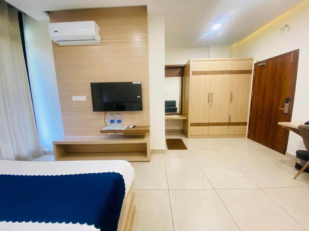 ein Wohnzimmer mit einem TV und einem Sofa in einem Zimmer in der Unterkunft Mount view by farstay in Wayanad