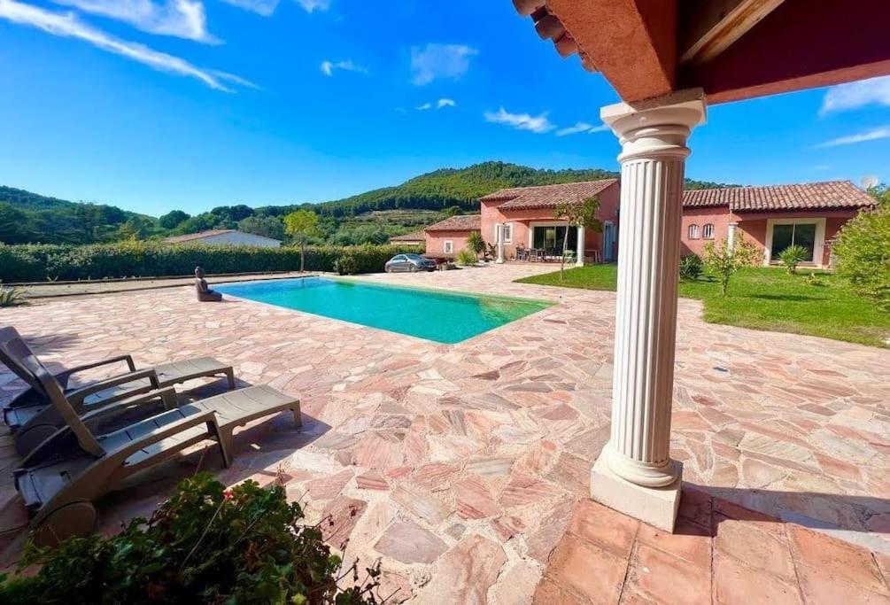 un patio avec deux chaises et une piscine dans l'établissement Appartement indépendant en rdc dans propriété, à La Madrague