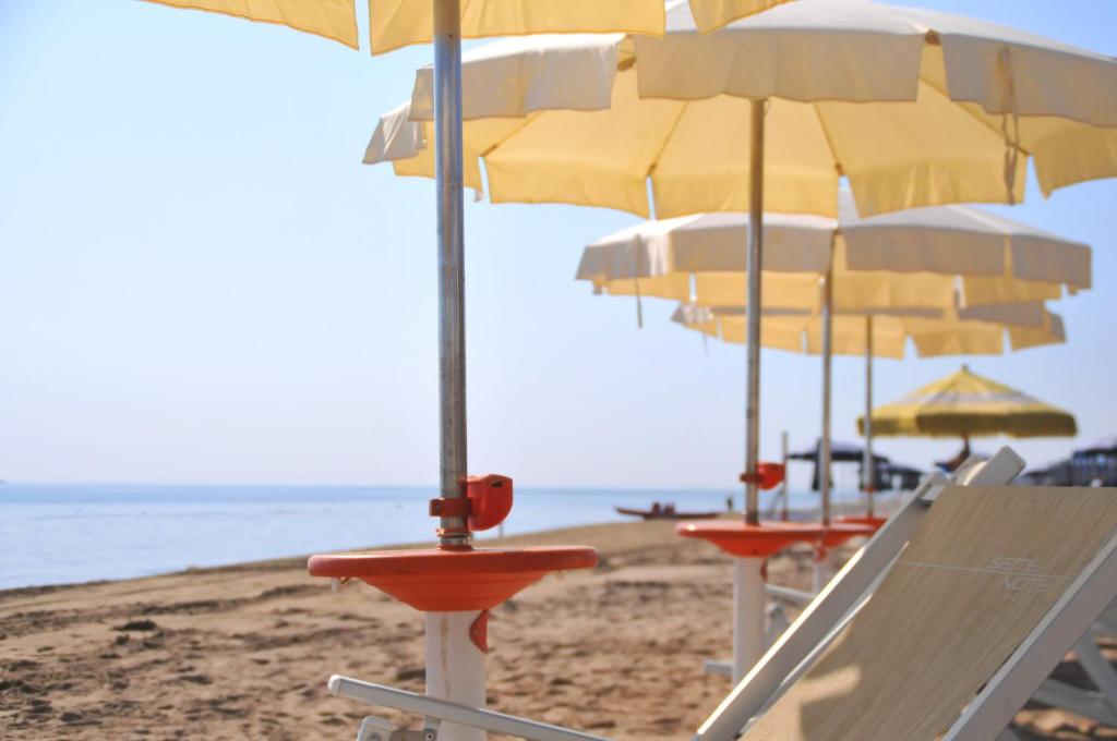 a group of chairs and umbrellas on a beach at Hotel Sette Note in Silvi Marina