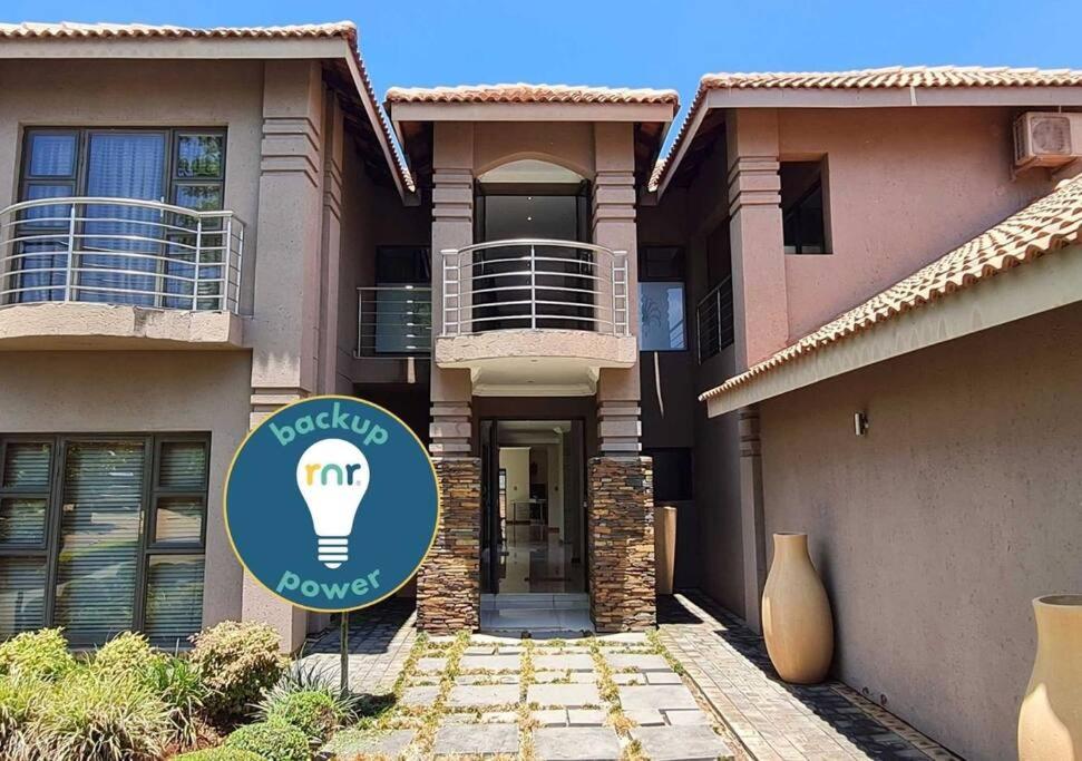 a building with a light bulb sign in front of it at 10 Pecanwood Dr 4 Bedroom Beauty in Hartbeespoort