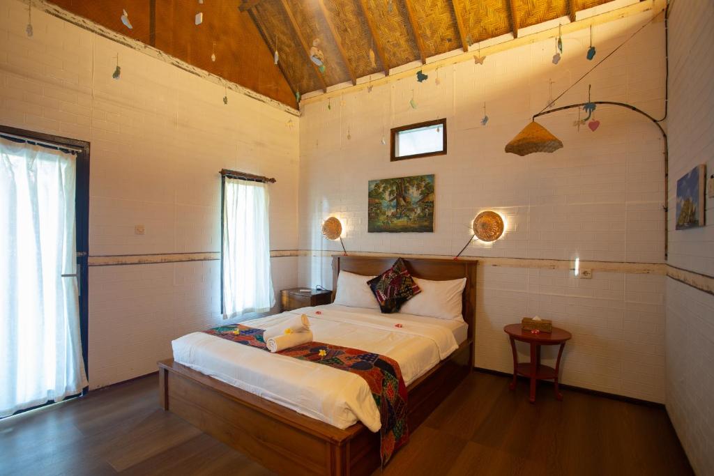 een slaapkamer met een bed in een kamer bij Fullmoon Bungalows in Toyapakeh