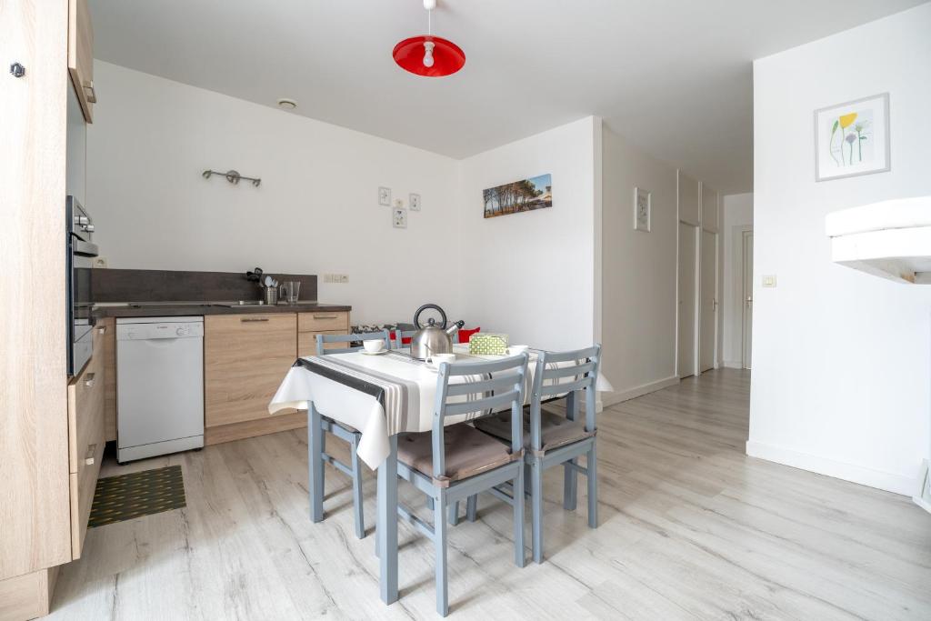 a kitchen with a table and chairs in a room at Coeur de Ville 1 & 2 in Jonzac