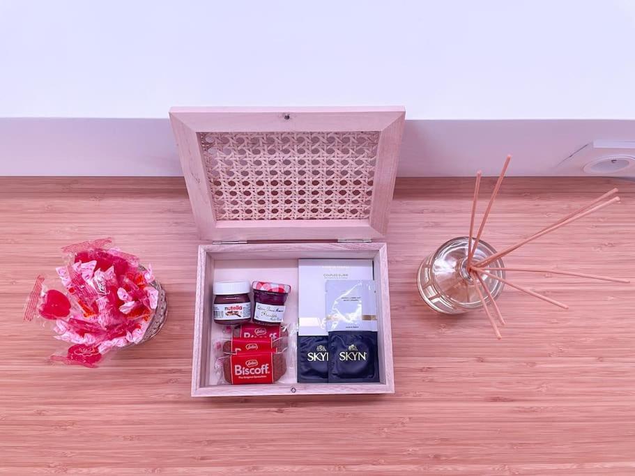 a small refrigerator on a floor with a bouquet of flowers at À la folie - Loft &amp; Spa in Montrevault